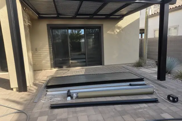 Fixed and motorized roof components over a paved patio at a home in Phoenix, AZ.