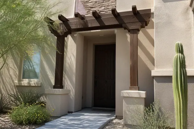 Newly installed pergola over a front entryway with desert landscaping and stucco walls in Phoenix, AZ.