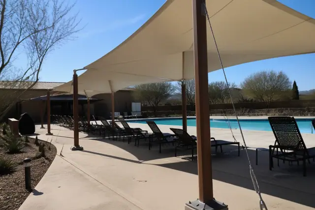 Large-span fabric canopies installed over a commercial pool deck in Phoenix, AZ.