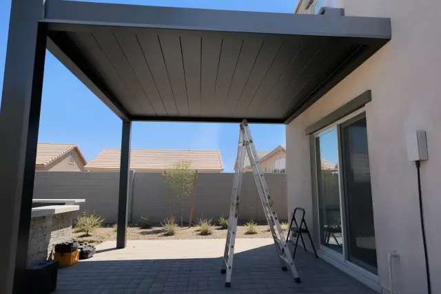 Louvered pergola installation over a stone patio with desert landscaping in Phoenix, AZ.