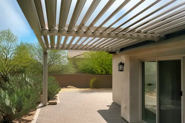 Louvered roof installation over a paved stone patio near a sliding glass door in Glendale, AZ.