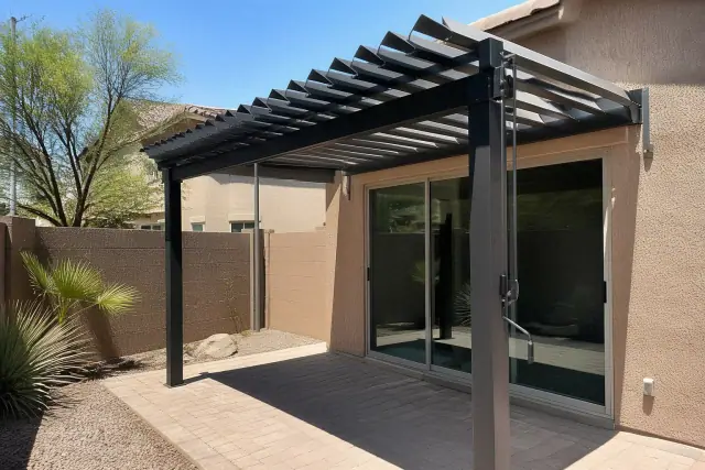 Manual louvered roof system over a paved residential patio in Phoenix, AZ with desert landscaping.
