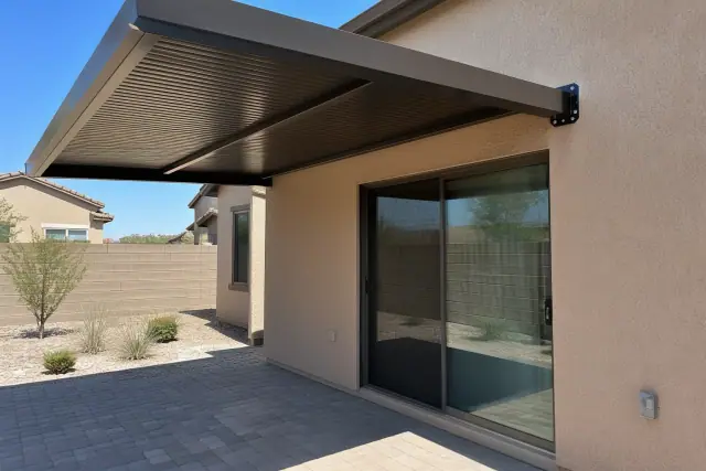 Metal awning installed over a paved patio next to a sliding glass door at a residence in Chandler, AZ.