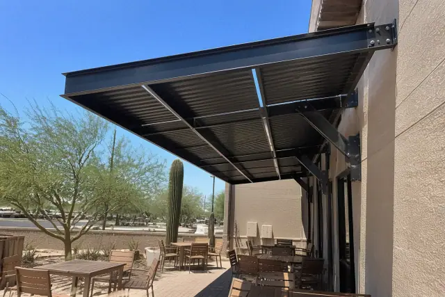Metal awning with steel support brackets over an outdoor dining terrace in Phoenix, AZ.