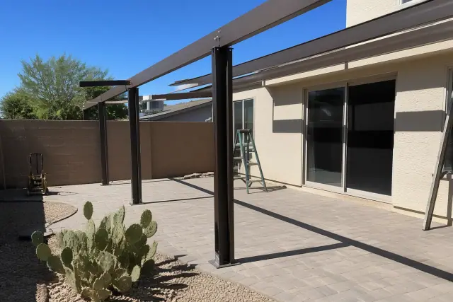 Patio cover installation with steel brackets and overhead beams at a residential backyard in Chandler, AZ.
