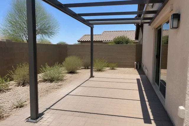Steel support posts and partially installed cross-beams for a patio cover in a backyard in Queen Creek, AZ.