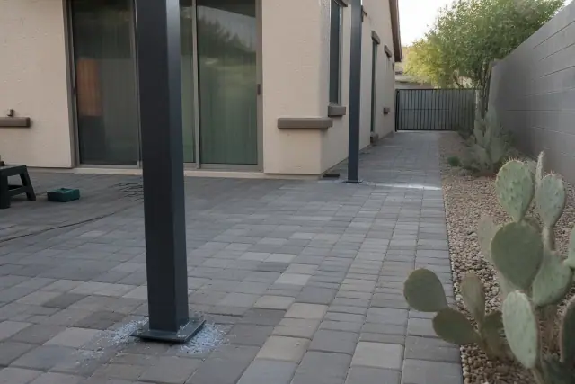 Steel support posts for a patio cover being installed on a stone patio at a desert home in Surprise, AZ.