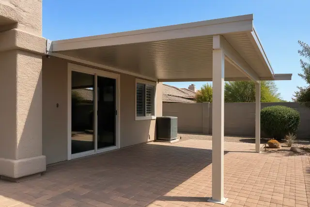 Aluminum patio cover installed over a residential backyard patio with anchored support posts in Mesa, AZ.