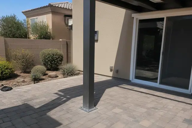 Metal patio cover support beam anchored into stone pavers at a residential backyard in Gilbert, AZ.