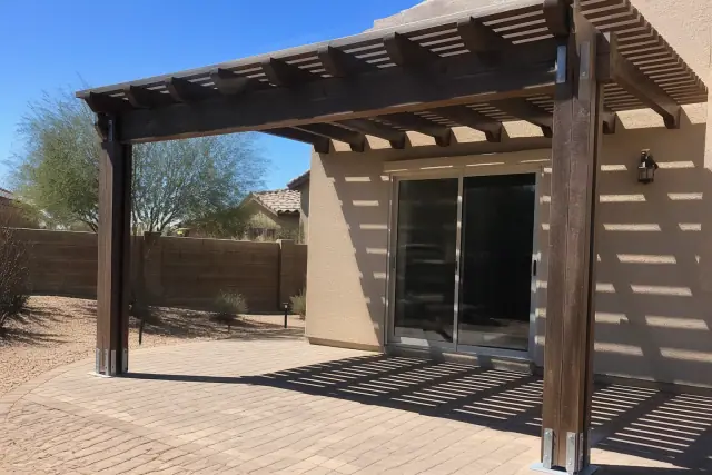 Newly installed timber pergola providing shade over a stone patio in a Goodyear, AZ backyard.