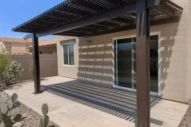 Completed pergola installation over a stone patio in a residential backyard in Glendale, AZ.