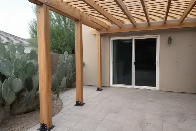 Newly installed cedar pergola posts on a stone patio outside a home in Gilbert, AZ.