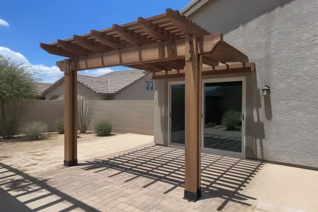 New cedar pergola installed over a paved patio in a Phoenix, AZ backyard with xeric desert landscaping.
