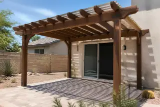 Wooden pergola structure over a stone patio with desert landscaping in a Phoenix, AZ backyard.