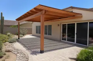 Newly installed wooden pergola providing shade over a stone patio in a Phoenix, AZ backyard.