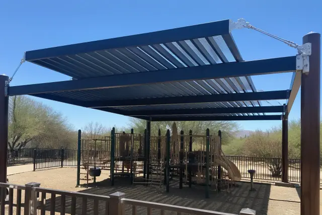 Pergola shade structure installed over climbing equipment at a public playground in Phoenix, AZ.
