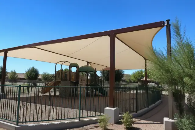 Steel playground shade structure with high-tension fabric canopy at a public park in Gilbert, AZ.