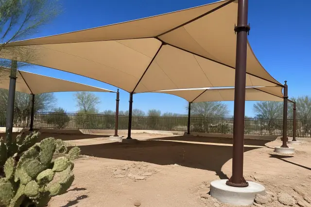 Playground shade structures with fabric canopies and desert landscaping in a Scottsdale, AZ park.