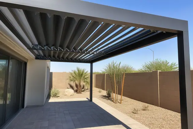 Motorized louvered roof system over a paved patio next to a sliding glass door in Phoenix, AZ.