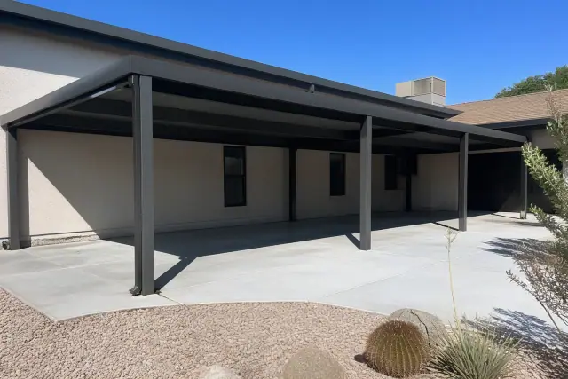 Metal carport and awning structure installed over a concrete slab in a Phoenix, AZ yard.