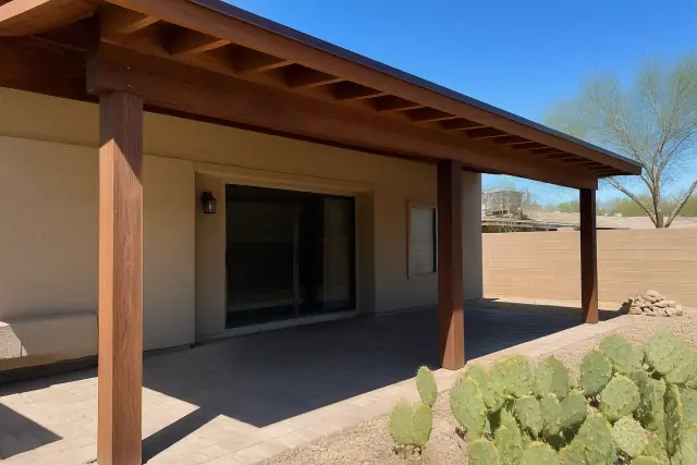 Completed wooden ramada over a paved patio with prickly pear cactus in a residential backyard in Phoenix, AZ.