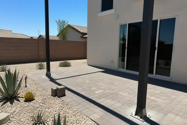 Steel support posts for a shade structure on stone pavers in a residential backyard in Queen Creek, AZ.