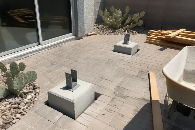 Concrete footings and posts for a backyard ramada roof installation in Phoenix, AZ with prickly pear cacti.