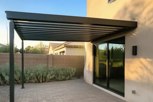 Pergola installation over a stone patio with prickly pear cactus near a sliding glass door in Phoenix, AZ.