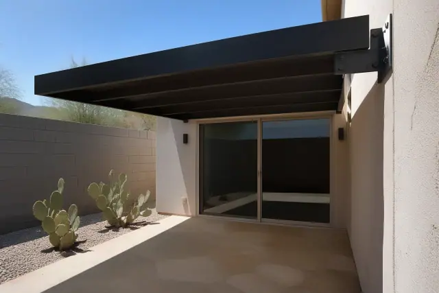 Cantilever shade structure over a stone patio with prickly pear cactus in a Phoenix, AZ backyard.