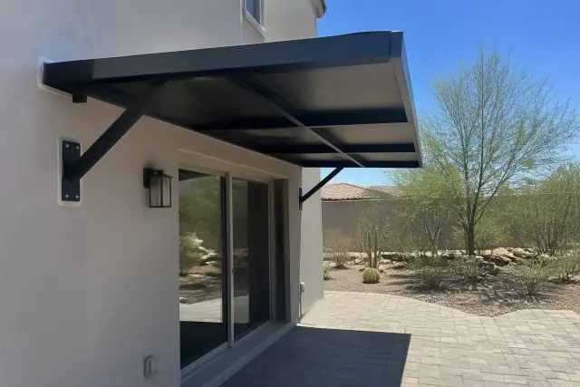 Newly installed aluminum awning over a sliding glass door on a stone patio in Phoenix, AZ.