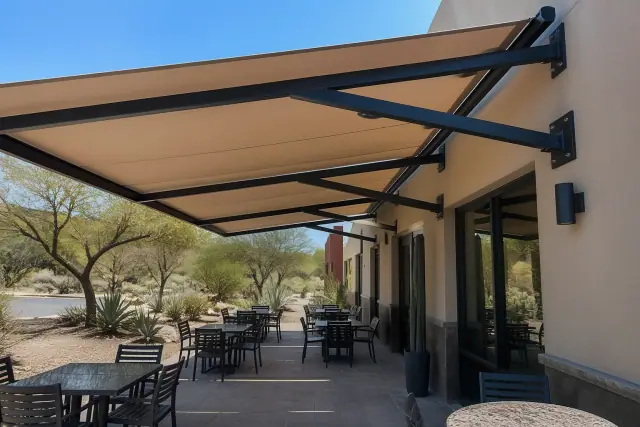 Cantilever shade structure with fabric canopy over an outdoor dining terrace in Phoenix, AZ.