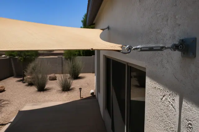 Shade sail installed over a residential patio with tensioned hardware in Mesa, AZ.