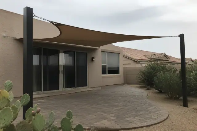 Triangular shade sails installed over a paved patio at a stucco home in Glendale, AZ.