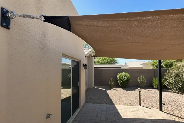 Shade sail installation over a residential backyard patio in Tempe, AZ.