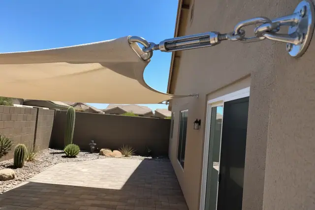 Shade sail installation with taut fabric canopy and metal hardware over a desert patio in Phoenix, AZ.