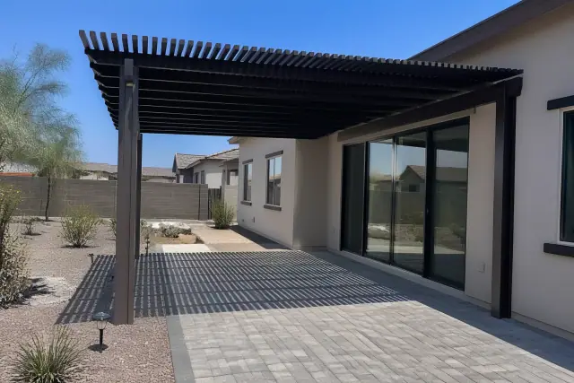 A newly installed shade structure over a stone patio in a residential backyard in Phoenix, AZ.