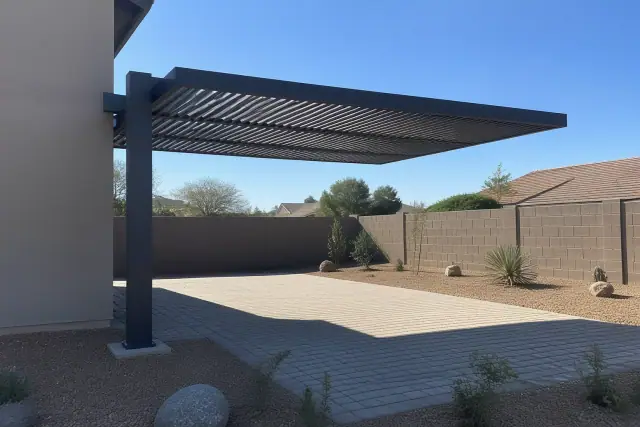 Single-cantilever shade structure over a stone patio in a Phoenix, AZ backyard with desert landscaping.