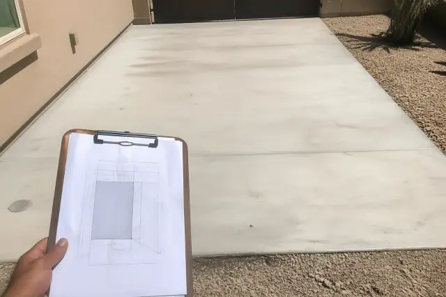 Site plan with setbacks and easements on a clipboard at a concrete driveway parking pad in Phoenix, AZ.