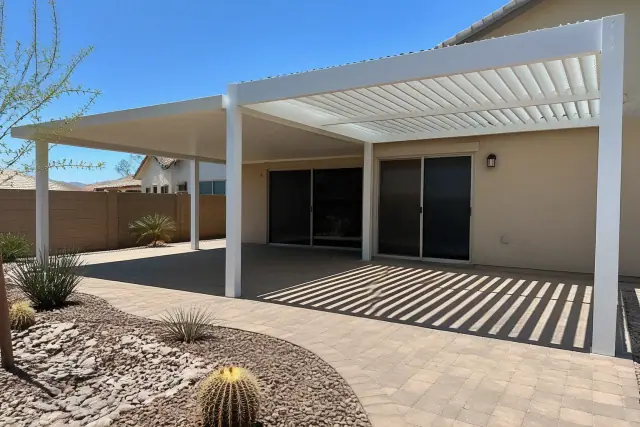 Solid and louvered patio roof at a residential backyard in Phoenix, AZ, with stone paving and desert landscaping.