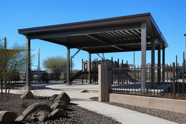 Solid-roof playground shade structures with steel posts at a public park in Phoenix, AZ.