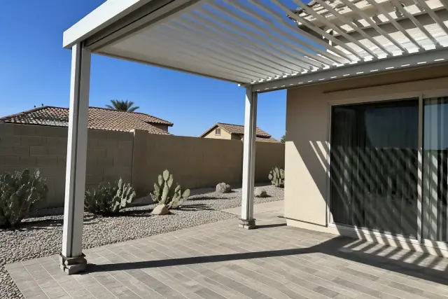 Standard aluminum louvered roof installed over a residential patio in Phoenix, AZ, with adjustable slats in the sunlight.