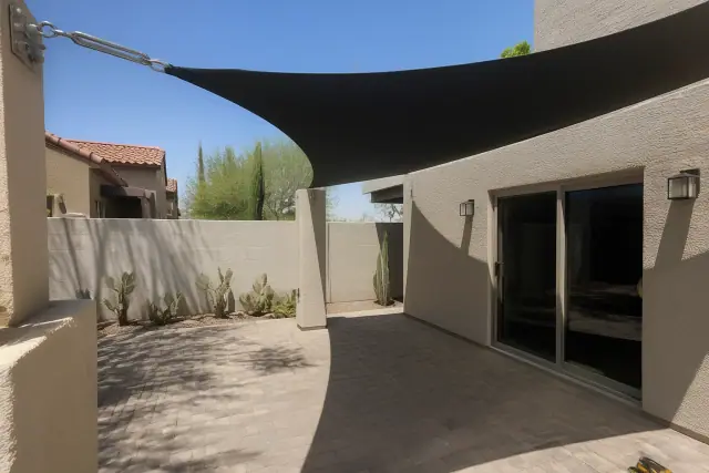 Waterproof shade sail installed over a paved patio with desert landscaping in Phoenix, AZ.