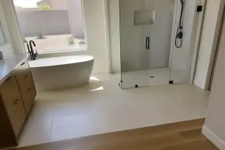 Finished modern bathroom floor tiles meeting a wood transition in a Phoenix, AZ home.