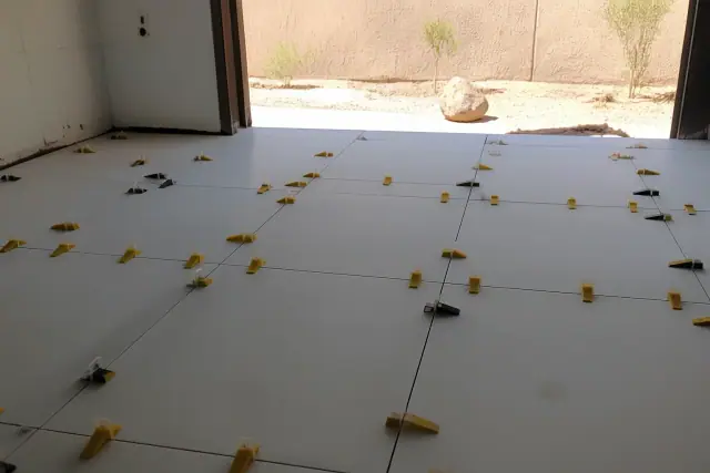 Ceramic tile installation with leveling clips and wedges on a bathroom floor in Phoenix, AZ.