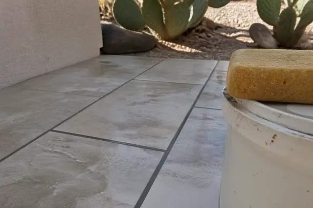 Newly installed porcelain floor tiles with fresh grout lines at a job site in Glendale, AZ.