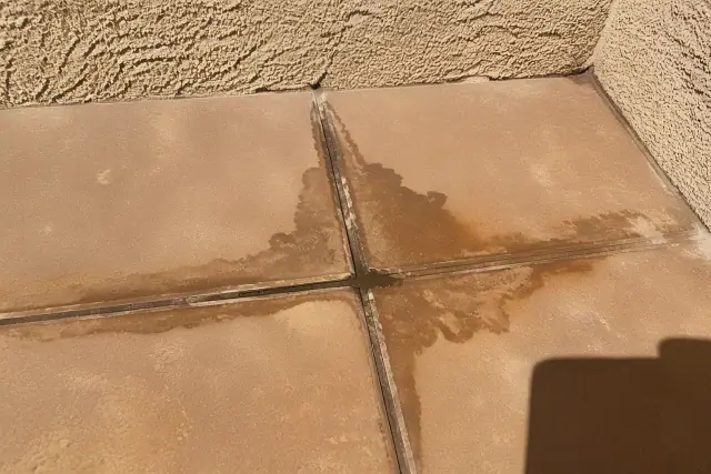 Cracked grout with moisture damage between ceramic floor tiles at a home in Phoenix, AZ.