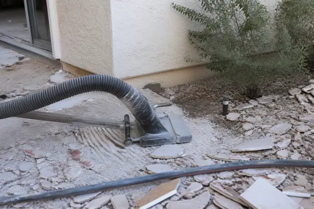 Industrial vacuum hose removing tile debris at a demolition site in Scottsdale, AZ.
