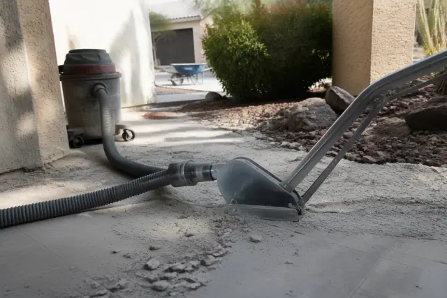 Industrial vacuum hose removing tile debris from a floor during a dustless renovation in Surprise, AZ.