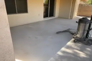 Industrial vacuum hose on a clean concrete floor after tile removal in a Phoenix, AZ home.