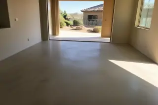Smooth concrete subfloor ready for tiling in a Phoenix, AZ home with sunlight from an open door.